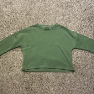 Women’s green sweater. Cropped.
